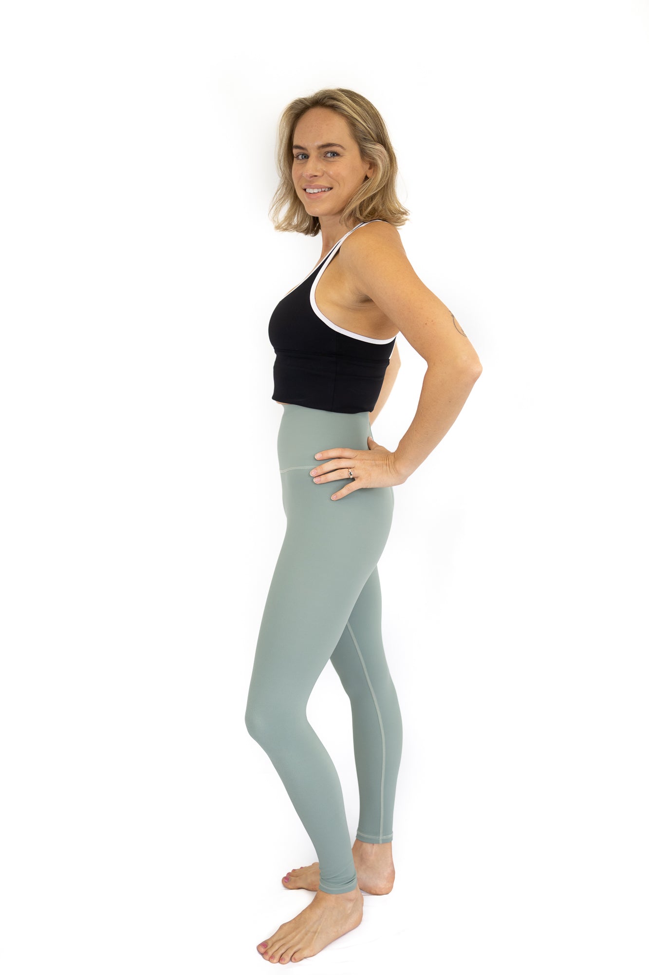 Woman in black top and blue leggings on final sale with limited sizes remaining