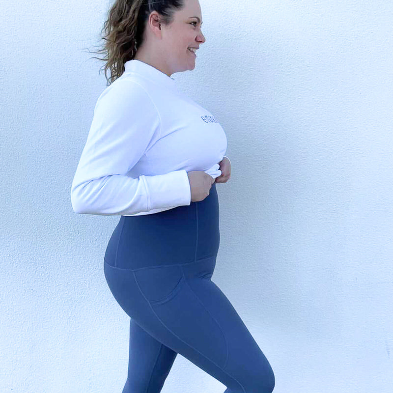 Woman in white long sleeves and blue leggings showcasing Emamaco shapewear style