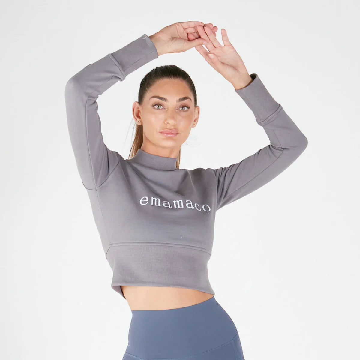 Woman posing in a crisp charcoal grey cropped sweatshirt with emamaco text