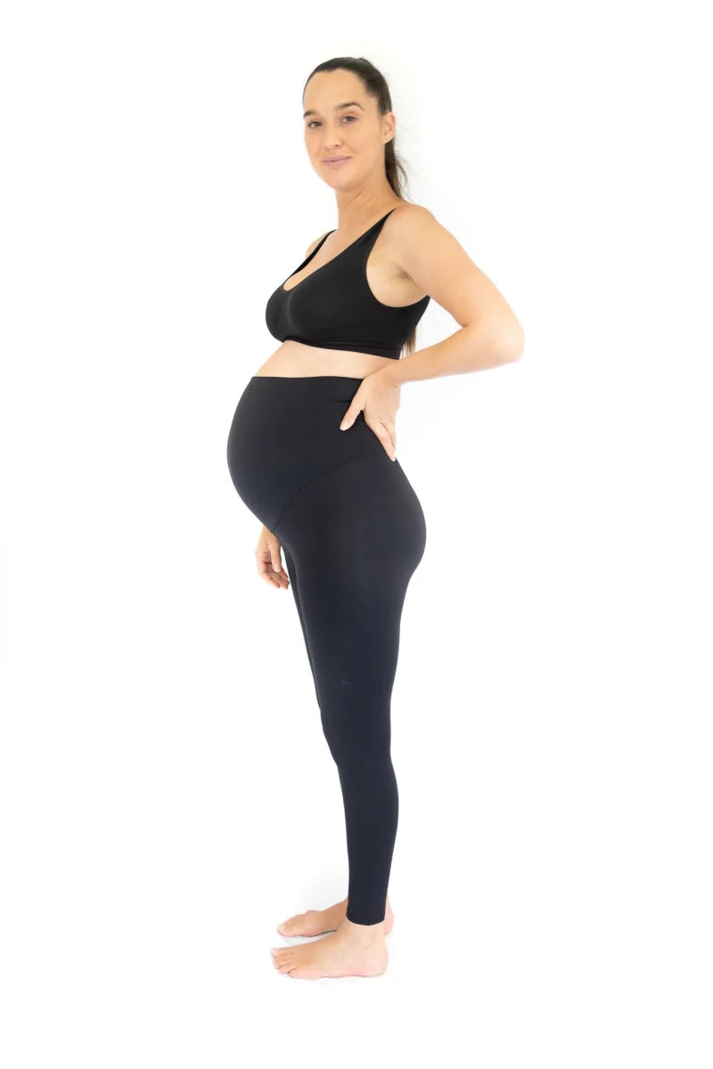 Pregnant woman in side pose showcasing Emama Maternity Leggings - Black - Full Length