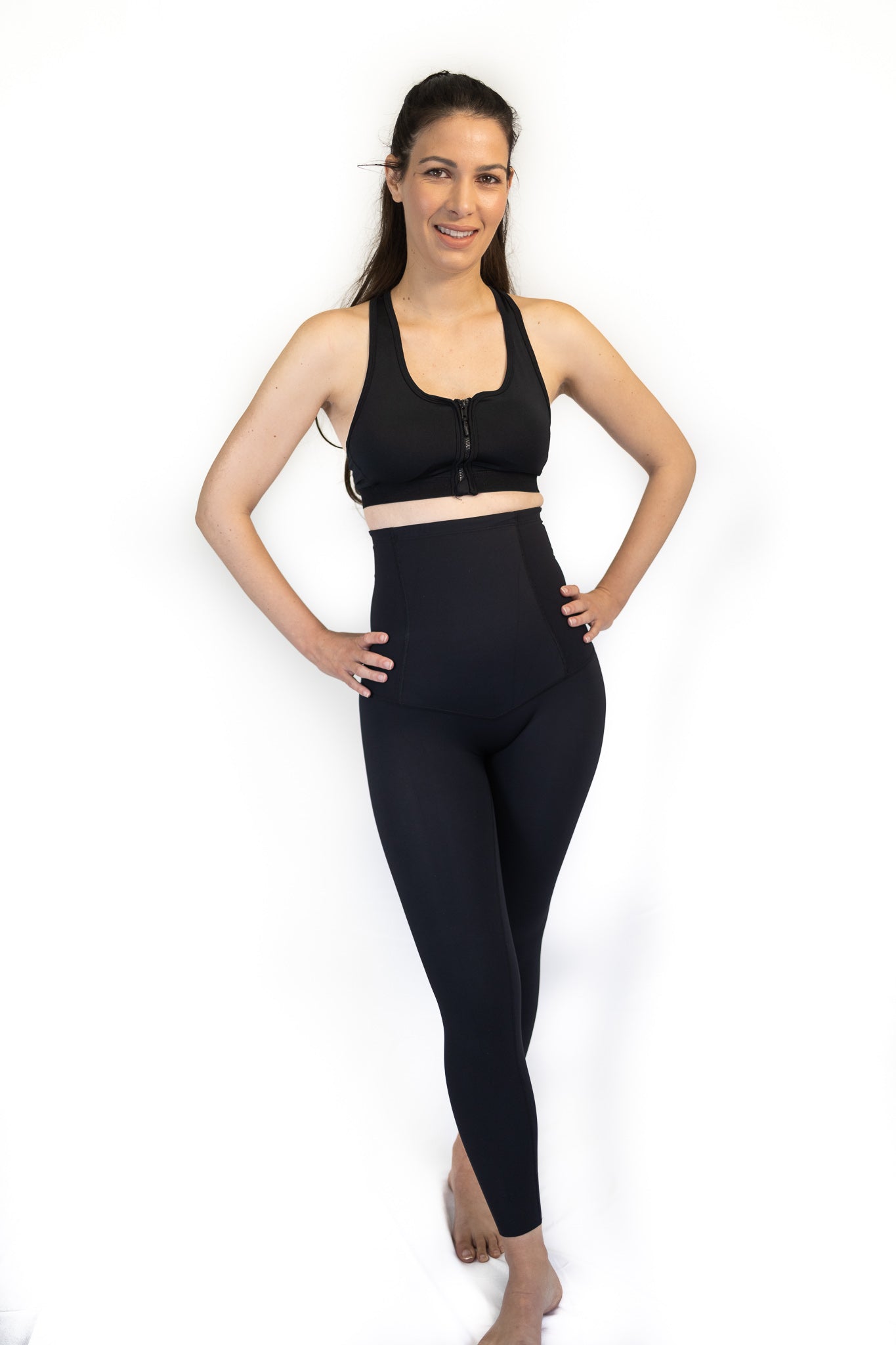 Woman in black sports bra and high-waisted leggings for best post partum recovery