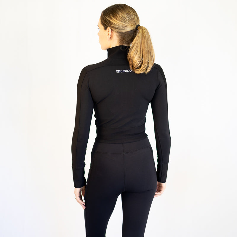 Black turtleneck sweater on a woman with ponytail, showcasing body hugging style