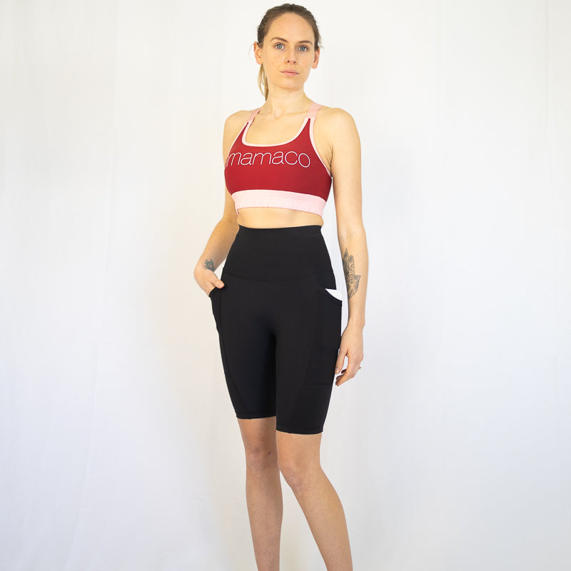 Woman in red sports bra and black long shorts, perfect for maternity and pet hair