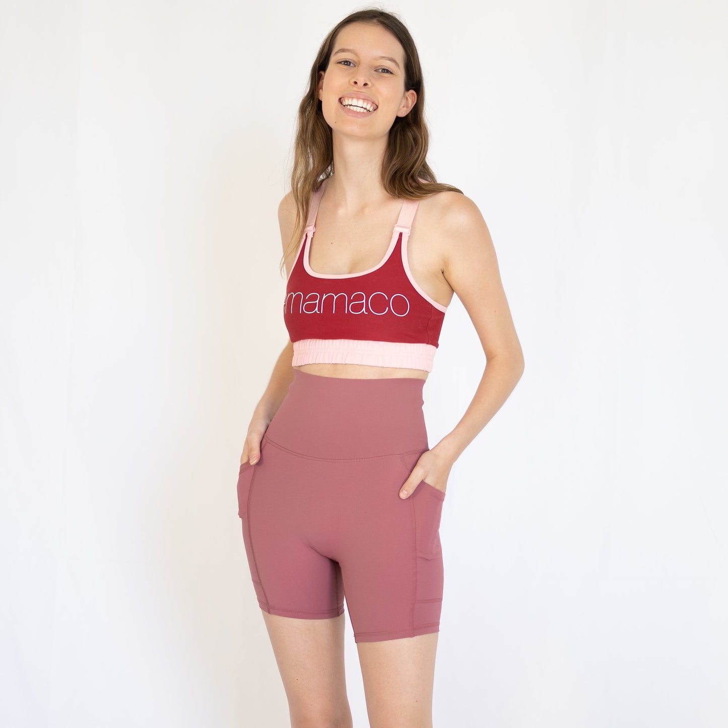 Woman in red sports bra and pink high-waisted shorts showcasing Shaper Move activewear