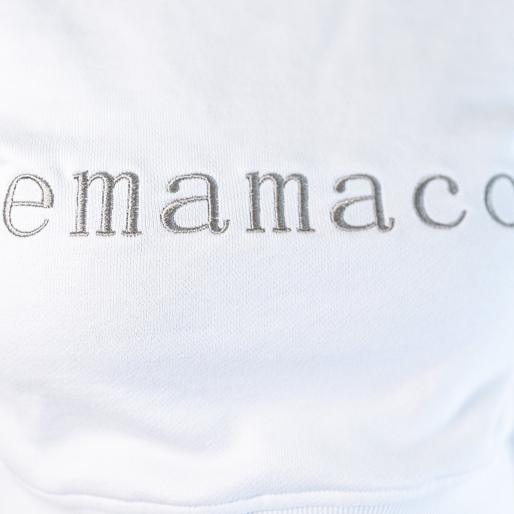 Delicately stitched emamaco logo on a light-colored Snow High Neck Jumper